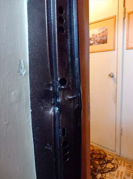 Поврежденный косяк металлической двери после вскрытия