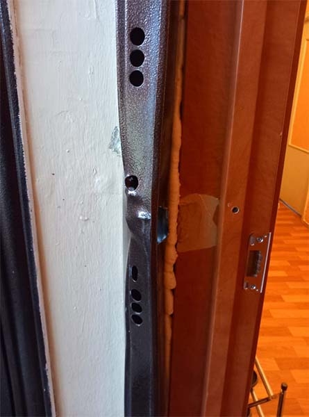 Деформированный косяк металлической двери после вскрытия